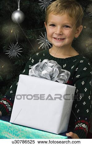 Boy carrying Christmas gifts View Large Photo Image Stock Photography - Boy carrying Christmas gifts. Fotosearch