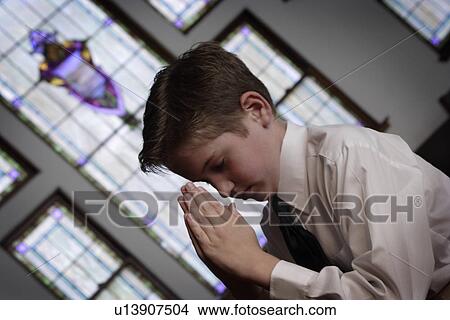 Boy praying in church environment View Large Photo Image Picture - Boy praying in church environment. Fotosearch