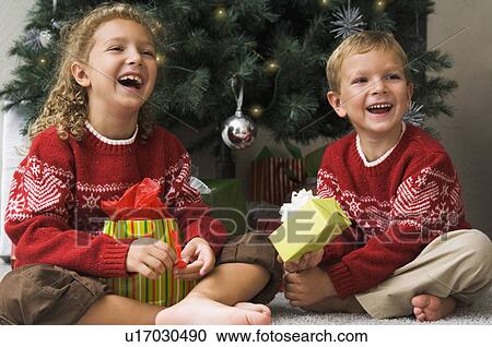 Stock Image - Children opening Christmas gifts. Fotosearch