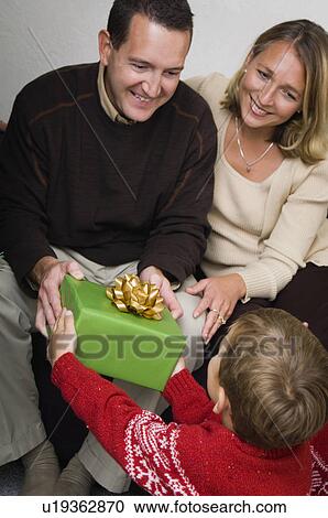 Family opening Christmas gifts View Large Photo Image Stock Image - Family opening Christmas gifts. Fotosearch