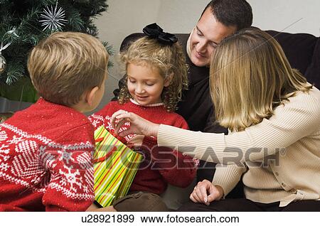 Stock Photo - Family opening Christmas gifts. Fotosearch