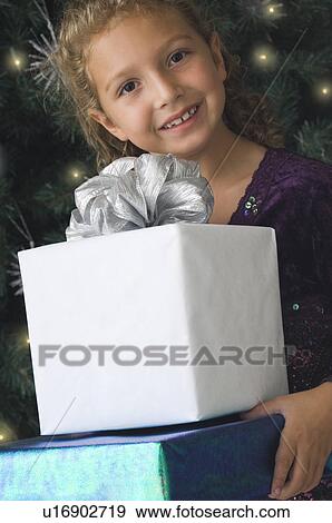 Stock Photo - Girl carrying Christmas gifts. Fotosearch