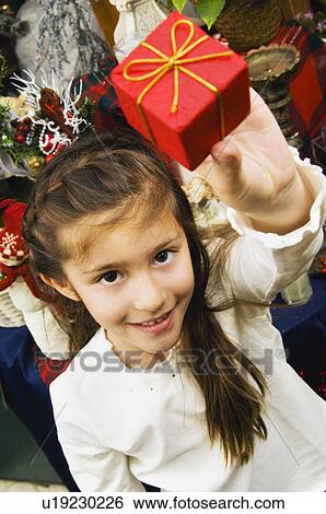 Girl holding gift View Large Photo Image Stock Photograph - Girl holding gift. Fotosearch