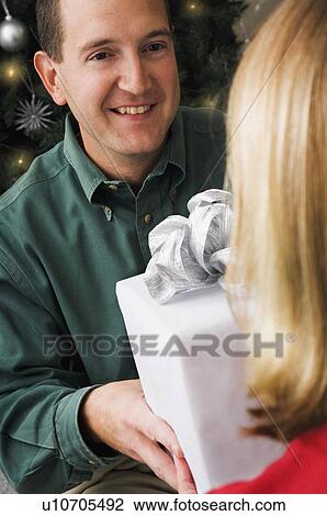 Man giving woman a Christmas gift View Large Photo Image Stock Image - Man giving woman a Christmas gift. Fotosearch