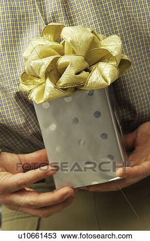 Man holding a gift View Large Photo Image Stock Image - Man holding a gift. Fotosearch