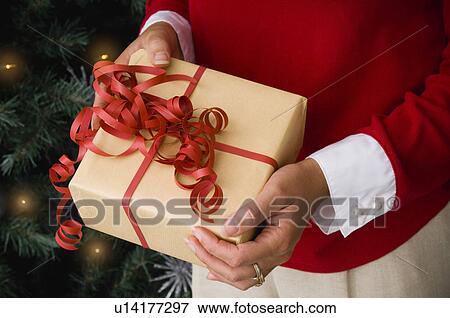 Woman holding Christmas gift View Large Photo Image Stock Photo - Woman holding Christmas gift. Fotosearch