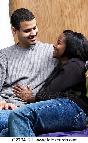 African American couple cuddling on couch View Large Photo Image Stock Image - African American couple cuddling on couch. Fotosearch