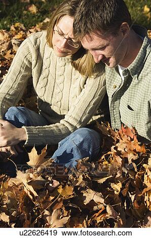 Stock Photo - Couple playing in fall leaves. Fotosearch
