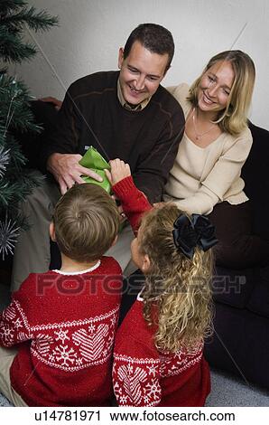 Stock Image - Family opening Christmas gifts. Fotosearch