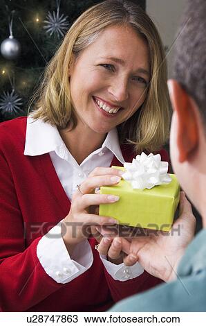 Stock Image - Man giving woman a Christmas gift. Fotosearch