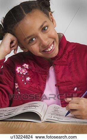 Picture - African American girl doing homework. Fotosearch