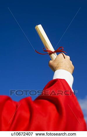 Stock Photo - Graduate holding diploma up in the air. Fotosearch