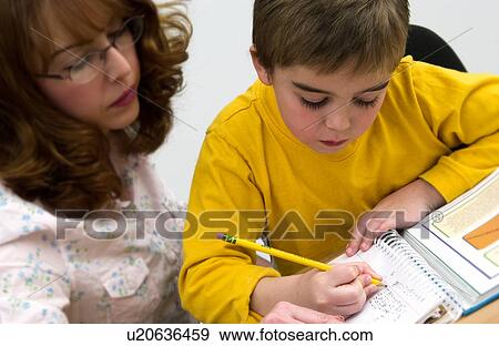 Stock Photo - Mother helping son with homework. Fotosearch