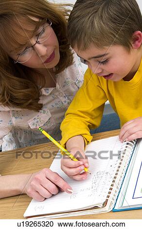 Mother or teacher helping boy with homework View Large Photo Image Stock Image - Mother or teacher helping boy with homework. Fotosearch