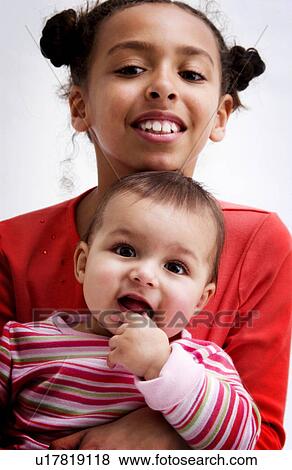 Stock Photo - African American girl holding baby. Fotosearch