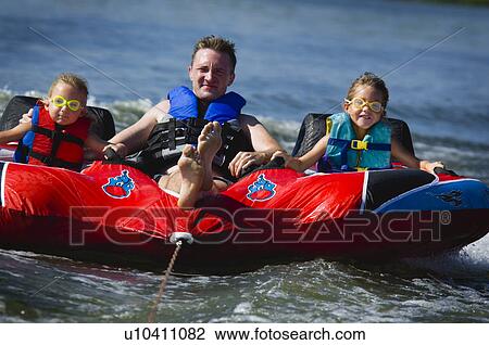 Stock Image - Dad with kids on inner tube. Fotosearch