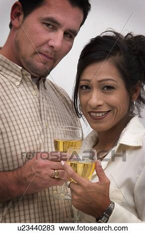 Stock Image - Hispanic couple making a champagne toast. Fotosearch