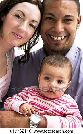 Stock Photograph - Mother and Father holding daughter. Fotosearch