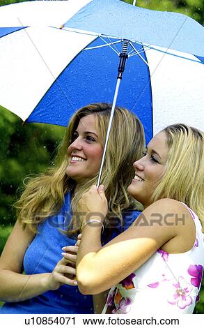 Two women under umbrella View Large Photo Image Stock Image - Two women under umbrella. Fotosearch