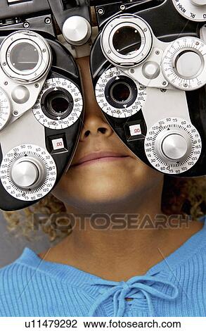Stock Image - African American girl getting eye exam. Fotosearch