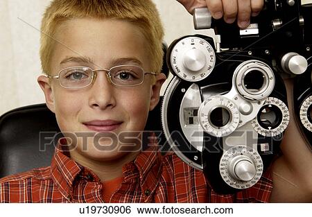 Boy getting eye exam View Large Photo Image Stock Photograph - Boy getting eye exam. Fotosearch