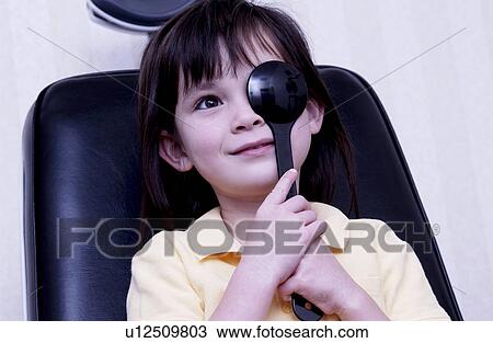 Stock Image - Girl getting vision tested. Fotosearch