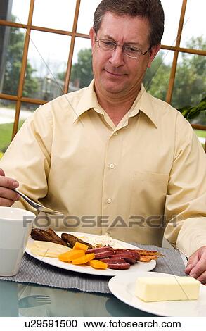 Man eating breakfast View Large Photo Image Stock Image - Man eating breakfast. Fotosearch