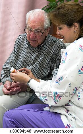 Nurse giving senior man a bottle of pills View Large Photo Image Stock Photo - Nurse giving senior man a bottle of pills. Fotosearch