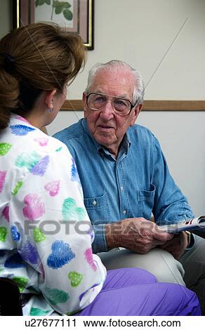 Stock Image - Nurse talking with senior man. Fotosearch