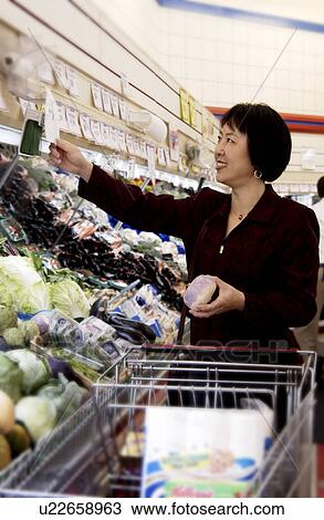 Stock Image - Oriental woman at grocery store. Fotosearch