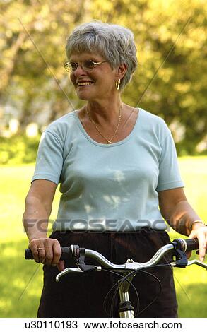 Senior woman riding bicycle View Large Photo Image Stock Image - Senior woman riding bicycle. Fotosearch