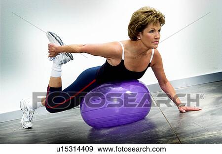 Stock Photo - Woman using exercise ball. Fotosearch