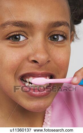 Stock Photo - Young African American girl brushing teeth. Fotosearch
