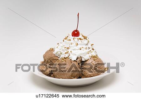 Dish of chocolate ice cream with whipped cream, cherry and nuts View Large Photo Image Stock Photography - Dish of chocolate ice cream with whipped cream, cherry and nuts. Fotosearch