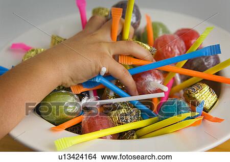 Picture - Kid grabbing Halloween candy. Fotosearch