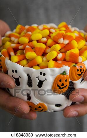 Man holding bowl of candy corn View Large Photo Image Stock Photo - Man holding bowl of candy corn. Fotosearch