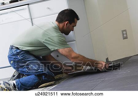 Construction worker laying tile floor View Large Photo Image Stock Image - Construction worker laying tile floor. Fotosearch