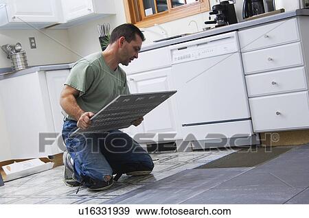 Stock Photo - Construction worker laying tile. Fotosearch