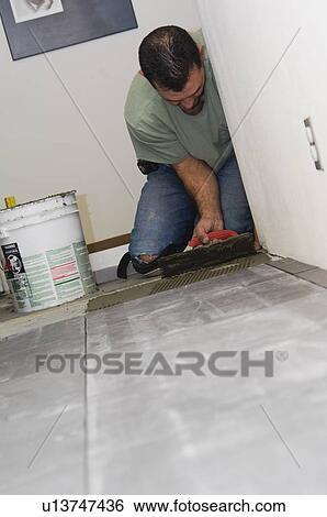 Construction worker laying tile View Large Photo Image Stock Photograph - Construction worker laying tile. Fotosearch