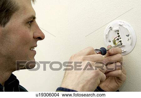 Man repairing thermostat View Large Photo Image Picture - Man repairing thermostat. Fotosearch