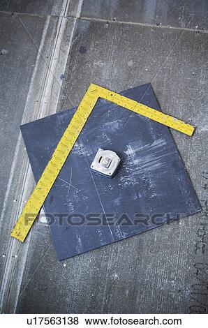 Stock Photo - Measuring tape, square, and tile on subfloor. Fotosearch