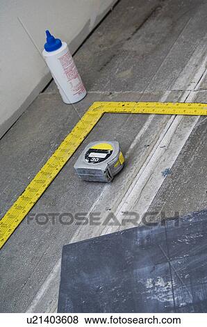 Stock Photo - Measuring tape, square, and tile on subfloor. Fotosearch
