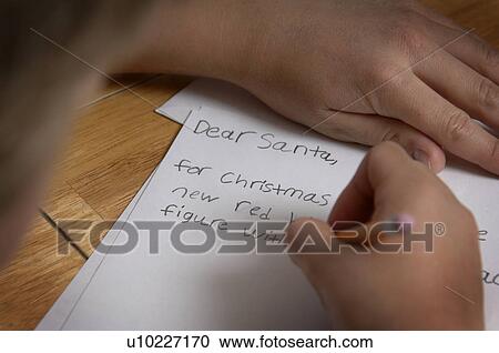 Stock Image - Boy writing letter to Santa. Fotosearch