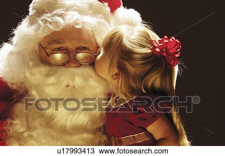 Stock Image - Girl kissing santa. Fotosearch
