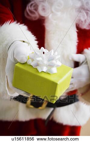 Stock Photograph - Santa holding gift. Fotosearch