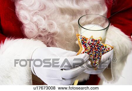 Stock Photo - Santa with cookie and milk. Fotosearch
