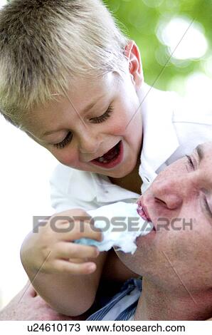 Stock Image - Boy feeding man cotton candy. Fotosearch