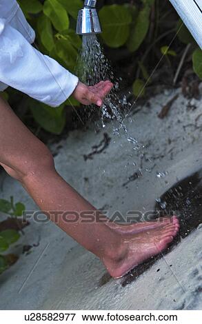 Child rinsing sand off View Large Photo Image Stock Photo - Child rinsing sand off. Fotosearch
