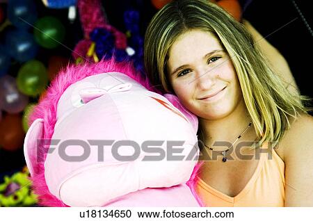 Girl at carnival holding stuffed animal View Large Photo Image Stock Image - Girl at carnival holding stuffed animal. Fotosearch