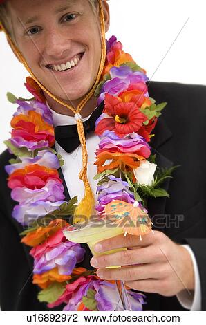 Stock Image - Man wearing a sombrero and flower lei and drinking a margarita. Fotosearch